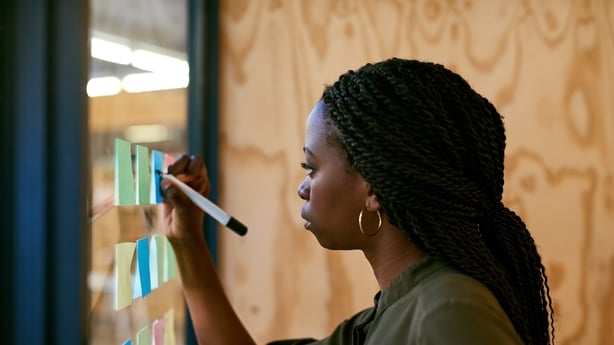 Cropped shot of a young designer writing her ideas on adhesive notes