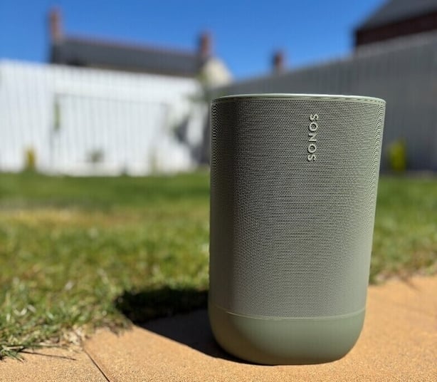 a grey speaker on a sidewalk