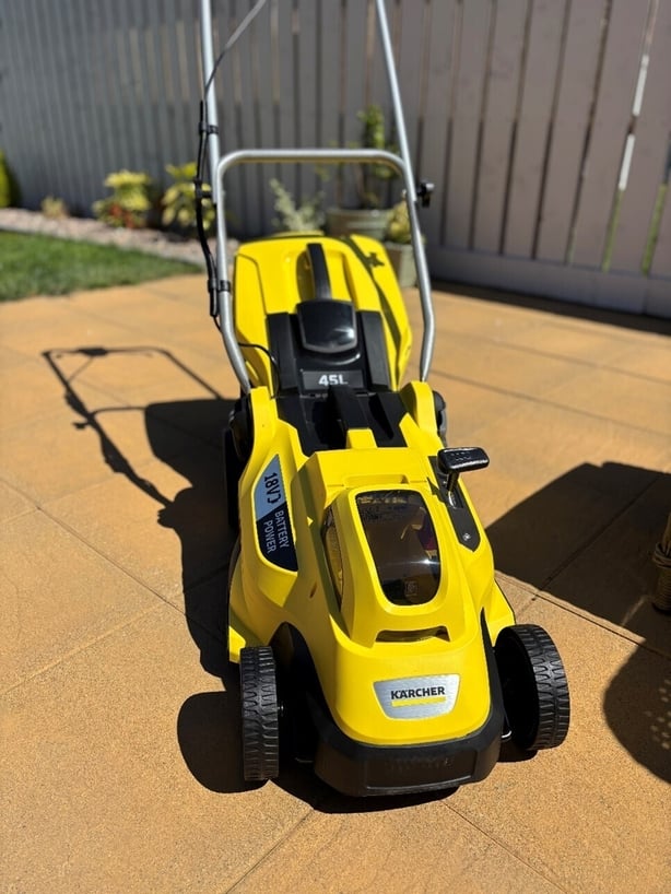 a yellow lawnmower on a patio
