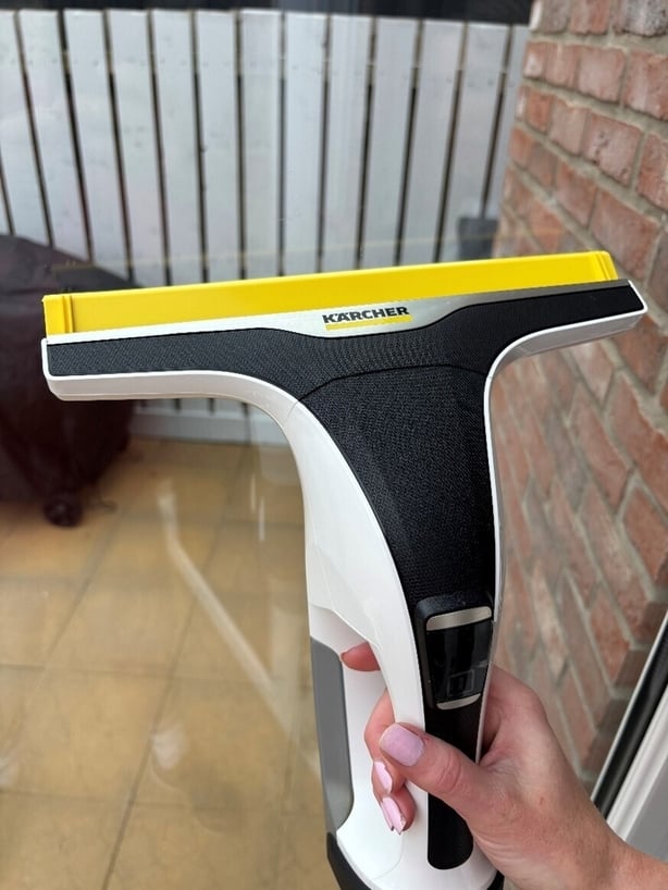 a hand holding a window cleaner
