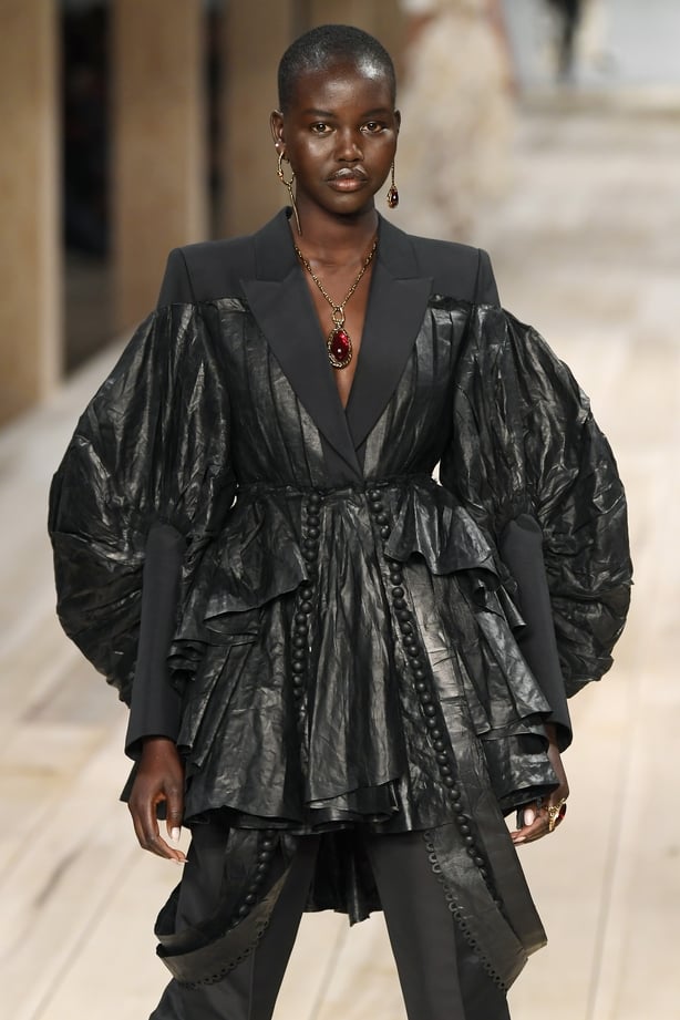 Adut Akech on the Alexander McQueen catwalk, wearing an oversized black jacket made from beetled linen