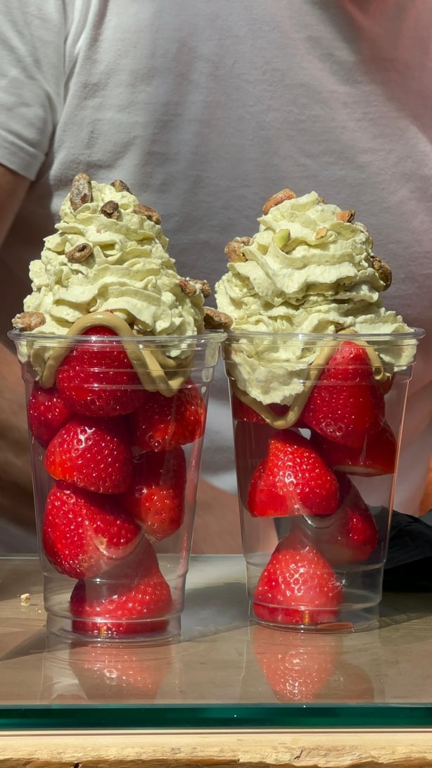 Two cups of strawberries topped with pistachio cream