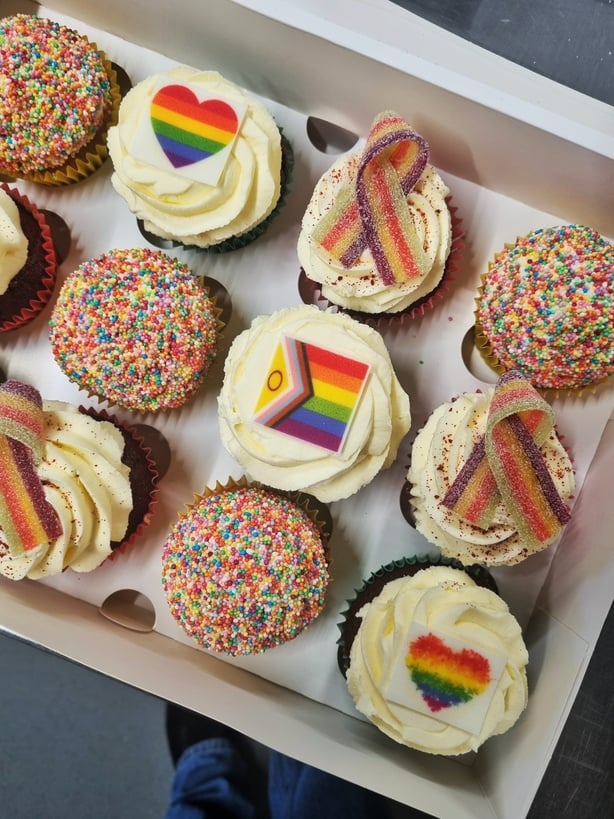 a box of cupcakes with rainbow and rainbow frosting