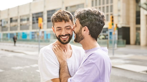 Lovely gay couple in love hugging in the street