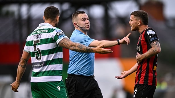 23 June 2025; Referee Kevin O'Sullivan with Lee Grace of Shamrock Rovers and Adam McDonnell of Bohemians during the SSE Airtricity Men's Premier Division match between Bohemians and Shamrock Rovers at Dalymount Park in Dublin. Photo by Ramsey Cardy/Sportsfile