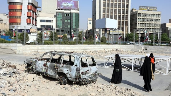 Iranians check on an ambulance that was destroyed during an Israeli strike on Tehran